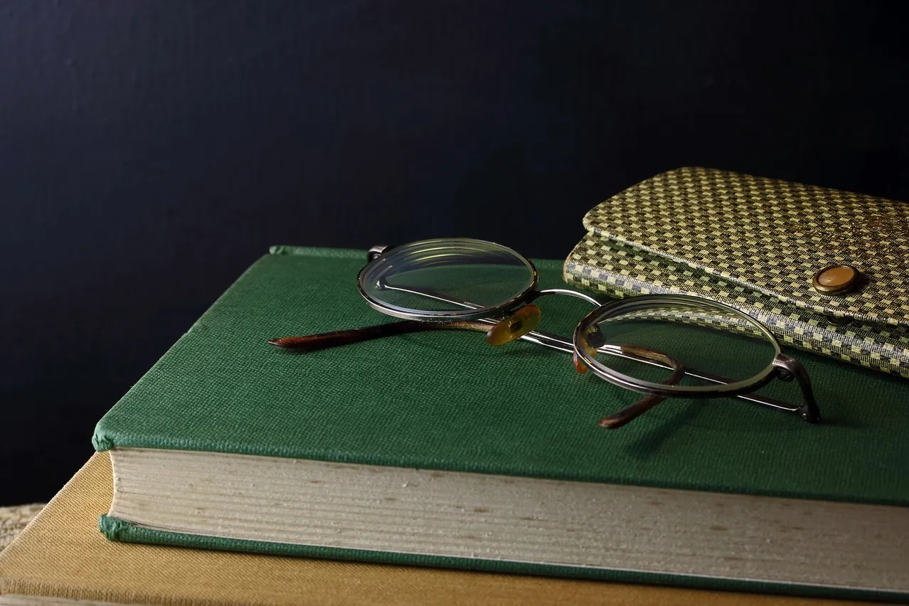Reading, hardcover book, spectacles