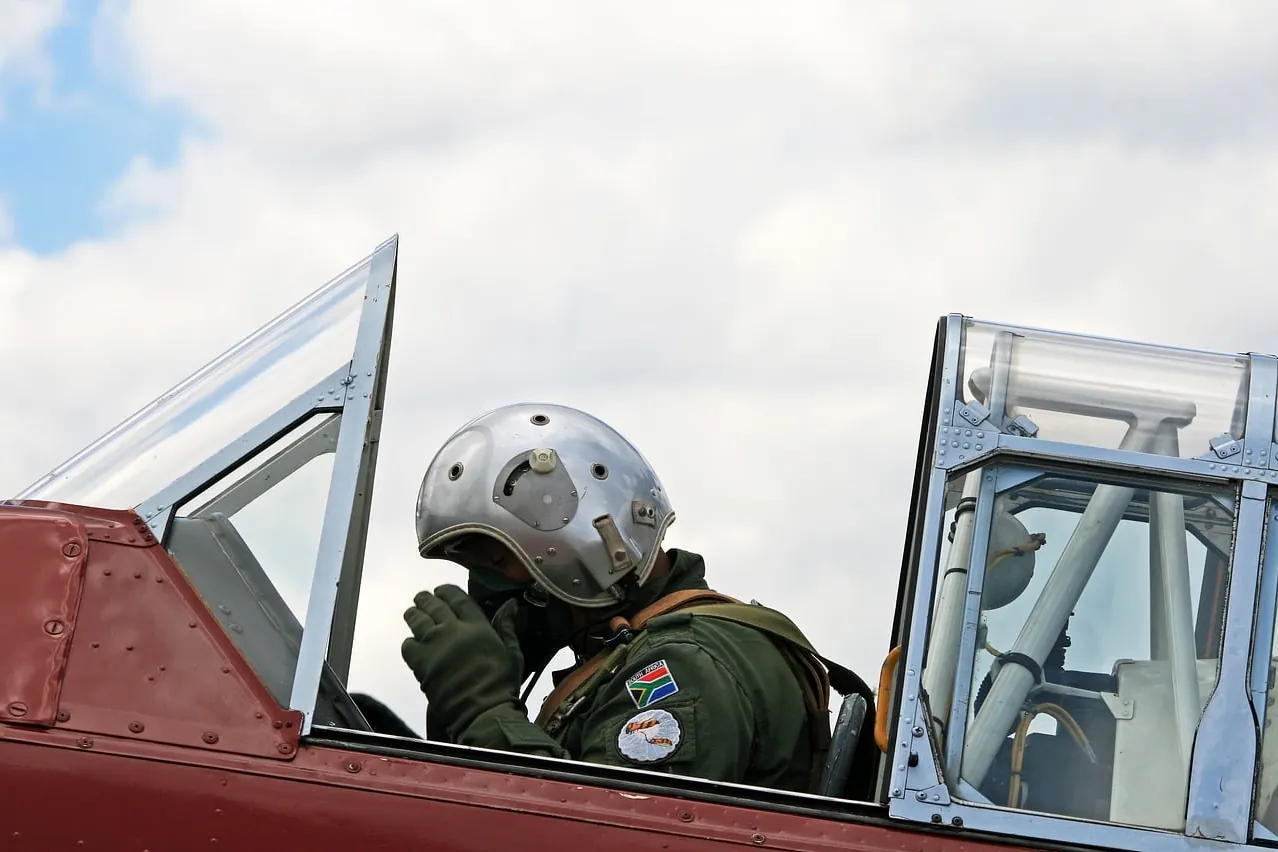Harvard pilot, adjusting oxygen mask, flying suit